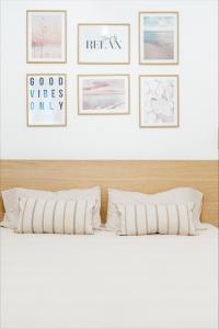 een slaapkamer met een bed met vier foto's aan de muur bij La Maison Calasetta in Calasetta