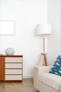 een woonkamer met een bank en een lamp bij La Maison Calasetta in Calasetta