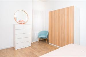 een slaapkamer met een houten deur en een blauwe stoel bij La Maison Calasetta in Calasetta +12 foto's