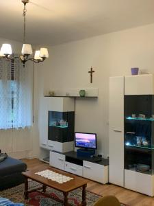 a living room with a tv and a cross on the wall at Appartamento luna, vicino centro storico in Spilimbergo