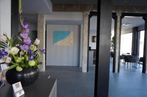 a lobby with a vase of flowers on a table at Hôtel Le Nautic in Arcachon