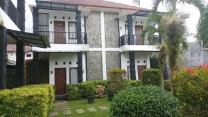 an apartment building with a courtyard with bushes at Beruk Angis Guest House & Kost in Palangkaraya