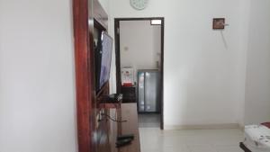an open door to a room with a refrigerator at Beruk Angis Guest House & Kost in Palangkaraya
