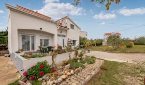 a house with a garden in front of it at Apartments Marija with big garden - TA Leut Agency in Vrsi