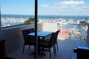 a table and chairs on a balcony with a view of a harbor at Hôtel Le Nautic in Arcachon