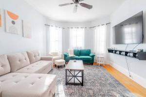ein Wohnzimmer mit Couch und Tisch in der Unterkunft Davis SQ 4BD/Free Parking/7 Min to Harvard & MIT in Winter Hill