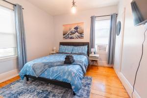 ein Schlafzimmer mit einem Bett mit einer blauen Bettdecke in der Unterkunft Davis SQ 4BD/Free Parking/7 Min to Harvard & MIT in Winter Hill