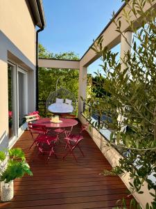 a patio with a table and chairs on a deck at Villa Metz / Amnéville 200m2 in Vigy