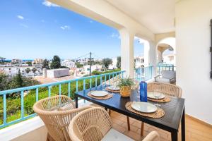 a balcony with a table and chairs and a view of the city at Carvoeiro -Spacious 2 bedroom appartment with pool - Monte Dourado in Carvoeiro