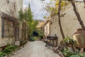 an alley in an old building with a bench and plants at El Sueño De Lucrecia in Villarrubia de Santiago