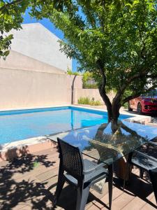 a table with a tree next to a swimming pool at Pink House - Lisbon in Lisbon