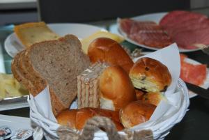 una cesta de diferentes tipos de pan sobre una mesa en B&B De Hagmolenbeek Boekelo, en Boekelo
