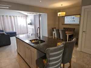 a kitchen with a sink and a table with chairs at Dublin Modern 4-5 bedroom house in Dublin