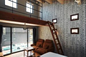a living room with a loft bed and a ladder at THE NEST 森の灯 MUNAKATA by ritomaru in Munakata