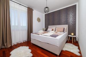 a bedroom with a large white bed and a window at Apartment Iva in Šilo