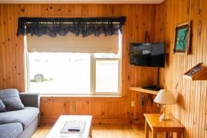 a living room with a couch and a window at Greenwich View Cottages (Unit #3) in Saint Peters