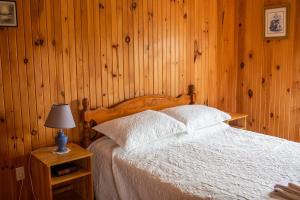 a bedroom with a bed with a wooden wall at Greenwich View Cottages (Unit #3) in Saint Peters