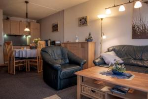 - un salon avec deux fauteuils en cuir et une table dans l'établissement Frische-Brise-03-04, à Cuxhaven