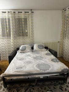 ein großes Bett in einem Schlafzimmer mit Vorhängen in der Unterkunft Apartment in Cergy Prefecture in Cergy