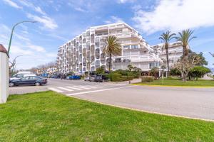 a large white building with cars parked on a street at Apartamento con Vistas al Mar in Empuriabrava +23 photos