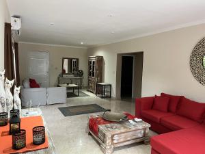 ein Wohnzimmer mit einem roten Sofa und einem Tisch in der Unterkunft Casa en Yanda, sobre Ruta Nacional 9, salida directa Autódromo in Zanjón