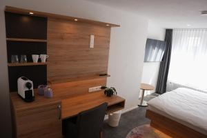 a bedroom with a bed and a desk and a bed and a bed at 7Rooms in Reutlingen