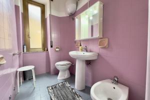 a pink bathroom with a sink and a toilet at Da Susanne, Central Agropoli apartment in Agropoli +6 photos