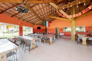 a restaurant with tables and chairs in a room at Chácara Santa Rita - Campo Magro | Gonzaga Stays in Campo Magro