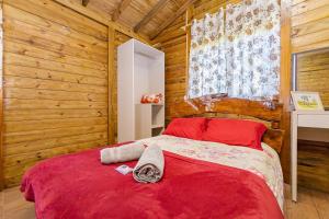 a bedroom with a red bed and wooden walls at Chácara Santa Rita - Campo Magro | Gonzaga Stays in Campo Magro +123 photos