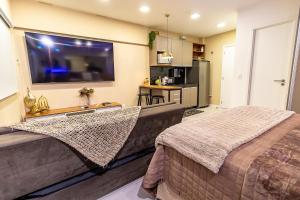 a bedroom with two beds and a large screen tv at STUDIO/ESTÚDIO TOP - Praia 200M & Lazer Incrível / Stylish Stúdio - 200M Beach & Great Amenites in Maceió