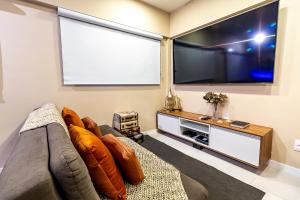 a living room with a large flat screen tv at STUDIO/ESTÚDIO TOP - Praia 200M & Lazer Incrível / Stylish Stúdio - 200M Beach & Great Amenites in Maceió +52 photos