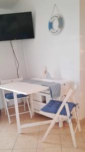 a white desk with a computer monitor and a chair at Sun and Sea Apartmani Vir Mali in Vir