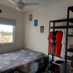 a bedroom with a bed and a rack of clothes at Quarto Nômade Digital in Aracaju +14 photos