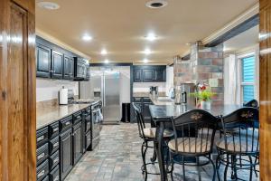 a kitchen with black cabinets and a table and chairs at Historic Home Near City Park Nola in New Orleans