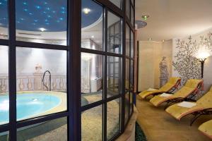 a room with a large window with a large tub at Hotel Auhof in Grossarl