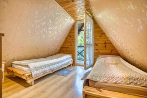 two beds in a room with a attic at Kryjówka Ichuna in Werlas