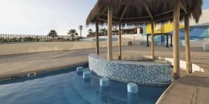 a swimming pool with a pavilion and a playground at Acogedor Dpto, Playa y Piscinas in La Serena