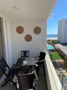 a balcony with a table and chairs on a building at Acogedor Dpto, Playa y Piscinas in La Serena