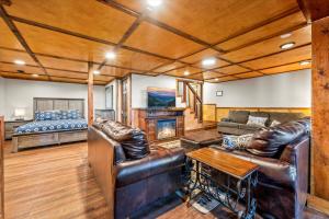 a living room with leather furniture and a bed at Mountain View Mansion in Gatlinburg