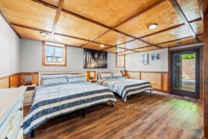 two beds in a room with wooden ceilings at Mountain View Mansion in Gatlinburg +141 photos