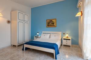 - une chambre avec un lit blanc et des murs bleus dans l'établissement Villa with pool and gardens with wonderful sea view, à Conca dei Marini 35 autres photos