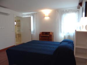 a bedroom with a blue bed and a window at appartamento Casanova in Venice