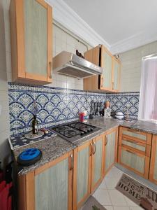 a kitchen with a sink and a stove top oven at Le Bon coin in Hammamet Nord