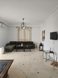 a living room with a couch and a table at Le Bon coin in Hammamet Nord