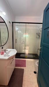 a bathroom with a shower and a sink and a glass door at Asian Everest House in Lisbon