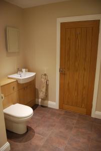 a bathroom with a toilet and a sink at Malvern Stables in Great Malvern