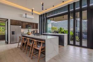 a kitchen with a large kitchen island with bar chairs at Entire homestay accommodation in Savegre de Aguirre, Costa Rica in Savegre