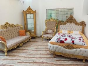 a bedroom with two beds and two chairs at Rajmahal in Sylhet