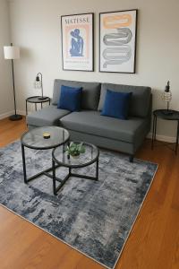 Una sala de estar con un sofá y dos mesas. en Cozy 2BR Apt near Parks & Shops - Kimball A2, en Chicago