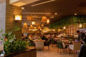 people sitting at tables in a restaurant with plants at K Suites in Quito